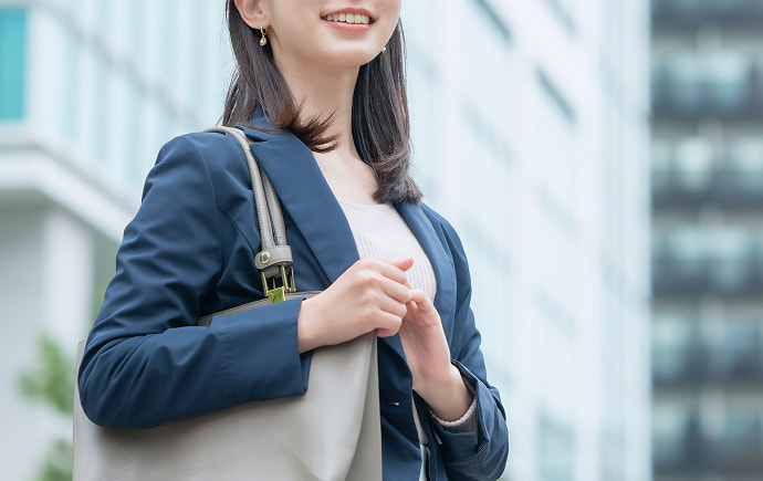 スーツを着てビル前を歩く女性