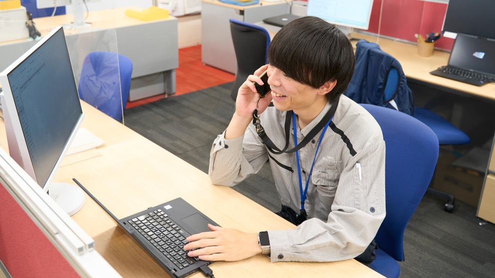 デスクで通話するR.U.さん