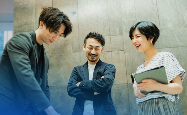 何かを指しながら談笑する三人組の男女